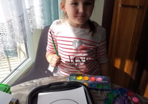 Amelka maluje farbami kolorowankę -"Jajko"